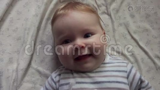 幸福的蓝眼睛宝宝躺在白色的毯子上视频