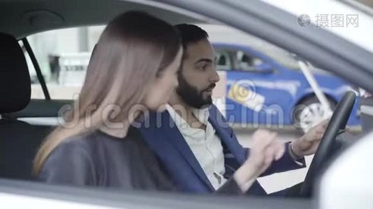 英俊的中东男人坐在车里，白种人的妻子作为商人关门的肖像。 积极成功视频