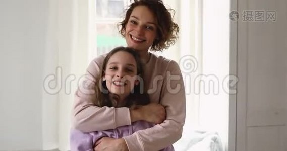 快乐深情的年轻妈妈抱着十几岁的女儿看镜头视频