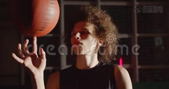 年轻的卷发白人肖像篮球运动员准备剪影旋转球在他的手指明亮视频