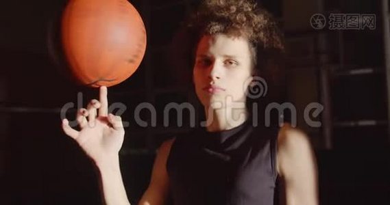 年轻的卷发白人肖像篮球运动员准备剪影旋转球在他的手指明亮视频