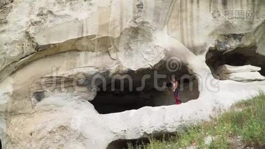 女旅行者穿过洞穴。 洞穴城附近的巴希萨拉伊-托普凯门。 克里米亚的景点。 慢动作视频