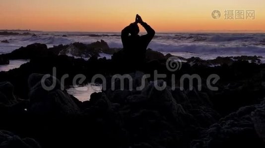 男人在日落或日出时在岩石石地平线上练习瑜伽。 自卫的艺术.. 背景的剪影视频