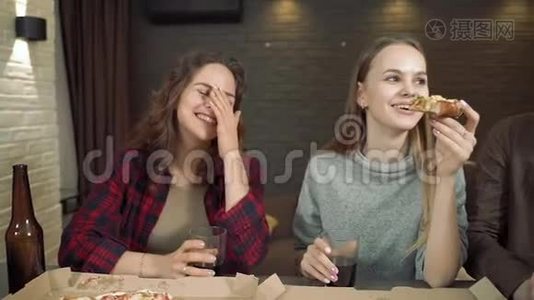 一群吃比萨饼的朋友在家里的客厅里一起谈笑风生。视频