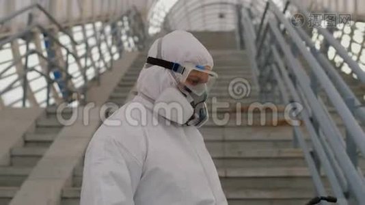 病毒学家穿着防护服在公共场所的扶手上喷洒化学品视频