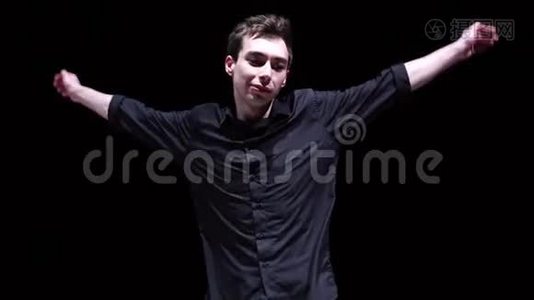 穿黑色衬衫的快乐男人在黑色背景上休息跳舞视频