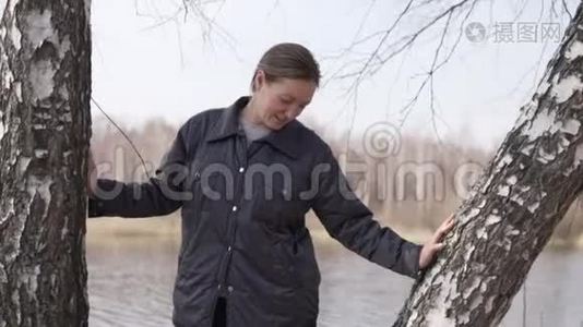 春天，一个女人站在桦树附近的树林里视频