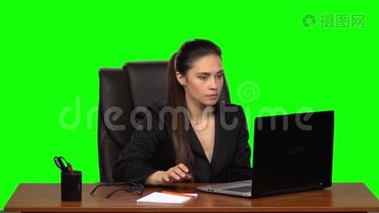 穿着衣服的女性热情地在笔记本电脑后面工作，非常生气。 绿色屏幕。 慢动作视频