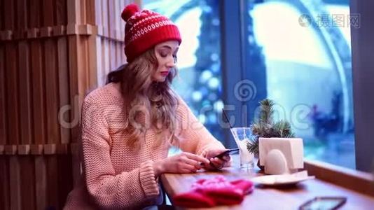 一个年轻漂亮的女孩独自坐在咖啡馆里，看着他心烦意乱的电话。视频