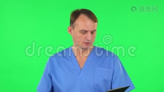 医务人员用pensil在黑色文件夹里填写文件。 绿色屏幕视频