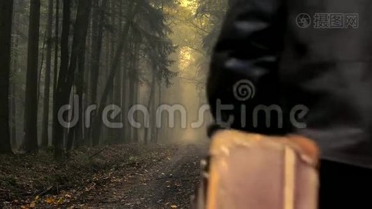 一个穿着旧衣箱的人，在雾蒙蒙的秋林里视频
