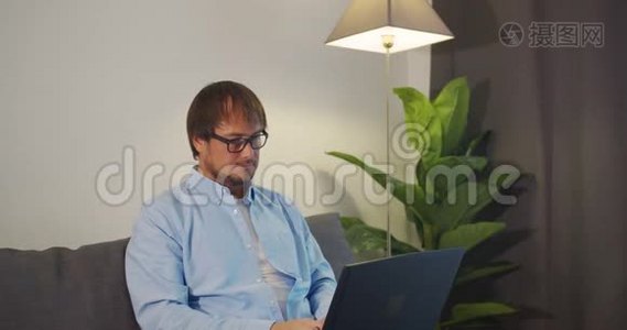 在电脑前努力工作的帅哥摘下眼镜，揉了揉眼睛。办公室职员，自由职业者。工作狂视频