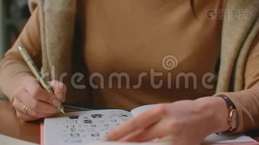 字体设计师用黑墨水毛笔在白纸画布上用字书法拼在上面视频