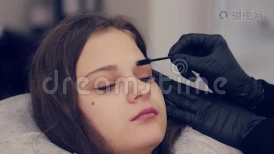 专业大师眉毛女士在美容院给客户梳眉毛。视频