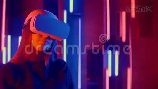年轻女子在霓虹灯中把VR耳机放在观众身上视频