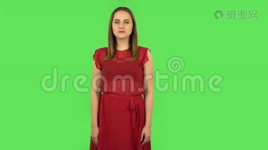 穿着红色裙子的温柔女孩正满怀期待地等待着。 绿色屏幕视频