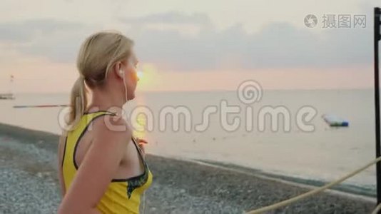 健身妇女在清晨慢跑。 在大海的背景下，太阳升起视频