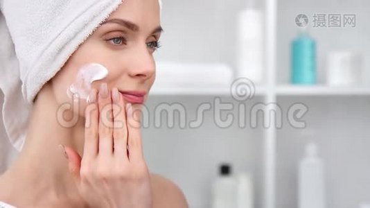 可爱的女性在脸上涂上化妆品水化霜。 中型近距离拍摄4k红色相机视频