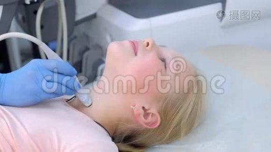 医生用超声波扫描仪检查女童甲状腺，特写。视频
