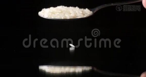 黑色背景反射桌面上落下的生米粒视频
