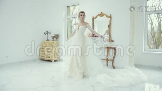 年轻的金发新娘穿着白色婚纱在镜头前摆姿势，转身视频