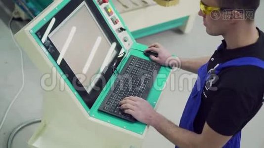 一名男性数控机床操作员正在控制面板上打字。视频