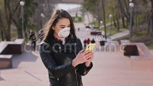 有魅力的年轻女性，戴着防护面罩，站在楼梯上的摄像机前用手机视频