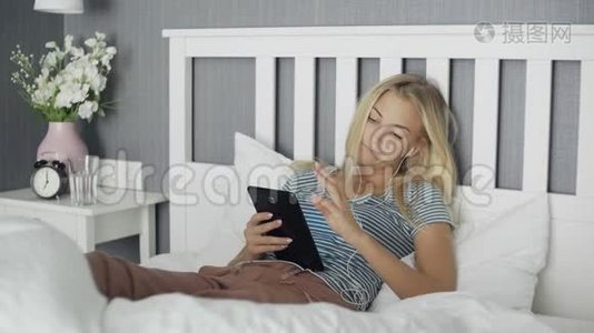 躺在家里的床上，躺在平板电脑里浏览社交媒体的无聊青年女子视频