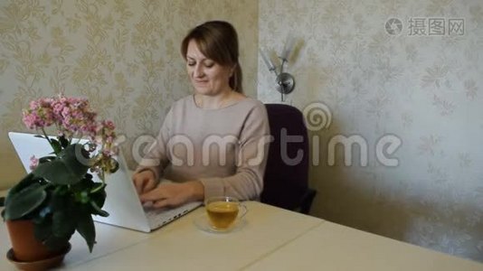 微笑的女人在家里的电脑里工作而不离开家视频