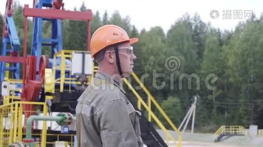 石油工人监督原油生产现场的慢镜头。 工业油泵千斤顶工作和抽油视频