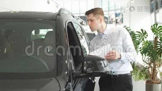 年轻的白种人在购买前检查新车。视频