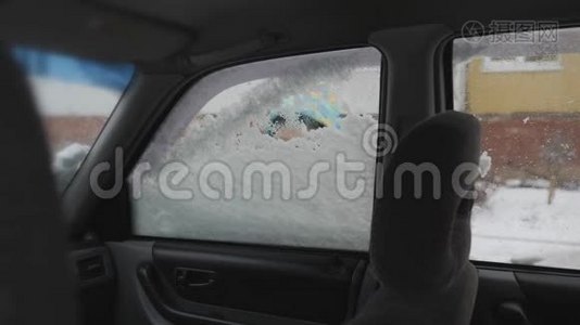 清理汽车侧窗积雪.. 一个孩子`手清洁汽车玻璃。 男孩笑得甜甜的视频