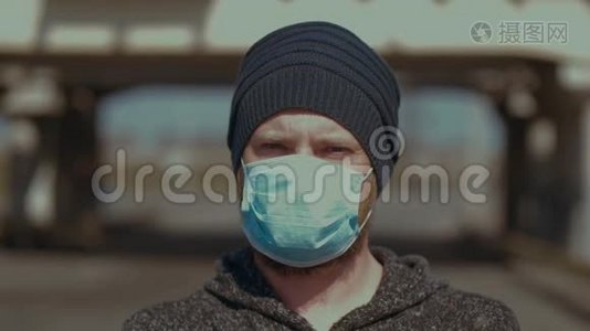 一个人站在户外，戴着医疗面罩，看着相机，以防止流感或冠状病毒。 日冕视频
