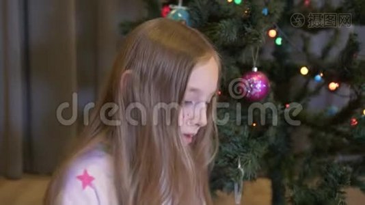浪漫少女在圣诞树背景上做梦。梦幻少年等待节日礼物视频