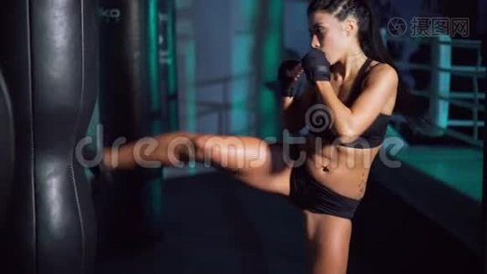 穿着运动绷带打拳击袋的女人。视频