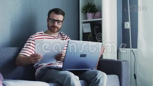 在家里拿着手提电脑和文件工作的商人视频