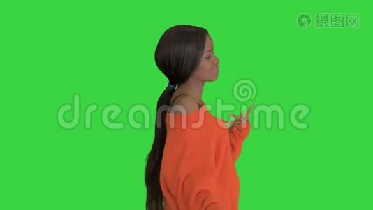 美丽的黑人妇女在绿色屏幕上微笑和跳舞，Chroma键。视频