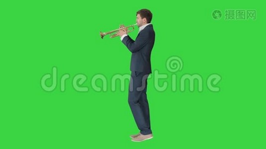 穿西装的音乐家在绿色屏幕上吹喇叭，Chroma键。视频
