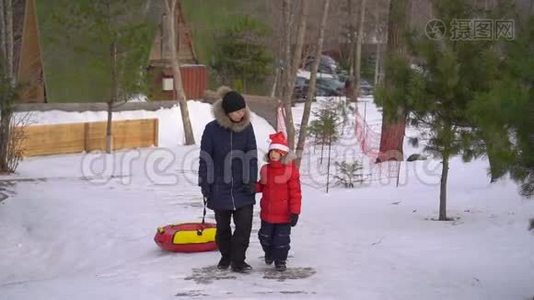 一个年轻的女人和她的小儿子在一个山区度假活动公园玩油管。 寒假概念视频
