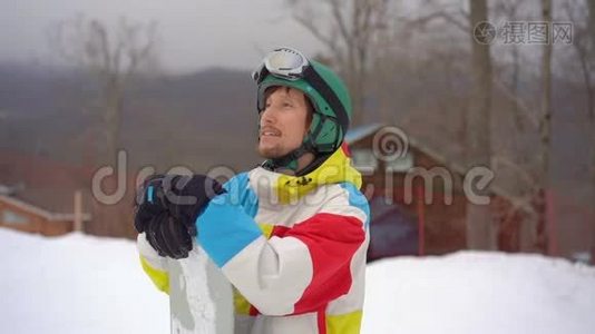 一个年轻人戴着头盔，在一个山区度假胜地用滑雪板拍摄的特写镜头。 寒假概念。 滑动视频