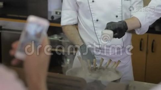 厨师们在餐厅的开放式厨房的酒吧桌上为顾客做白色制服的厨师视频