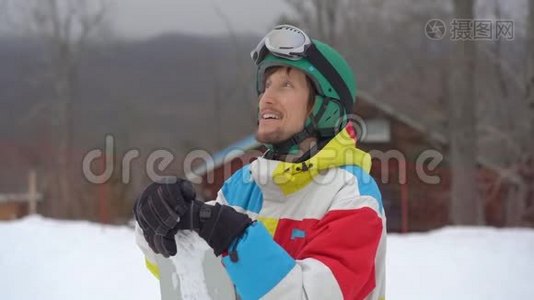 一个年轻人戴着头盔，在一个山区度假胜地用滑雪板拍摄的特写镜头。 寒假概念。 滑动视频