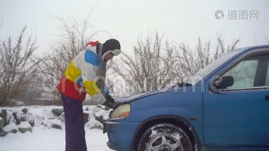 冬天，下着雪。 路上的人汽车出毛病了. 他正试图找出引擎的问题视频