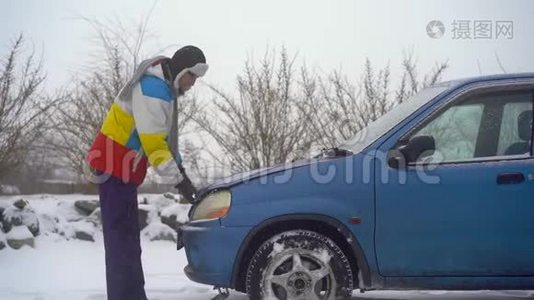 冬天，下着雪。 路上的人汽车出毛病了. 他正试图找出引擎的问题视频