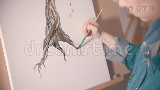 一位留着短发的年轻女子在一棵颜色更深的树干上作画视频