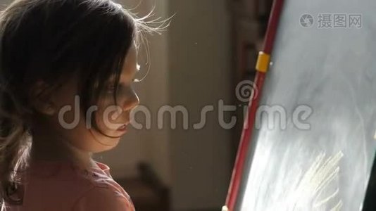 可爱的小女孩在粉笔板上用蜡笔画视频
