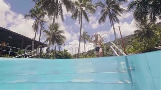 年轻人要去游泳，沿着游泳池的台阶，在热带岛屿上的豪华酒店休息。视频