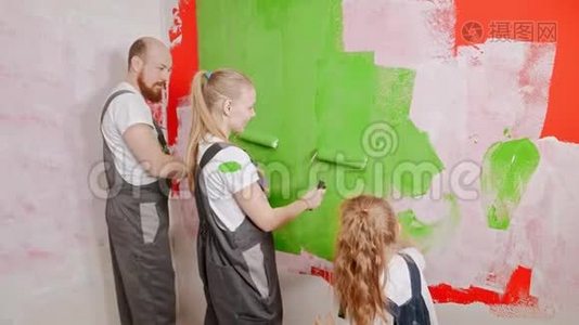 妈妈和爸爸在玩颜料，而女儿在画墙视频