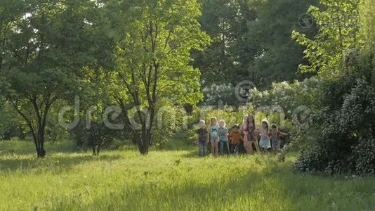 阳光明媚的夏日，一大群孩子穿着便服微笑着在公园里奔跑视频