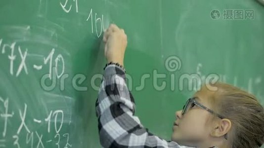 小学。 小女生在教室的绿色黑板上写数字视频